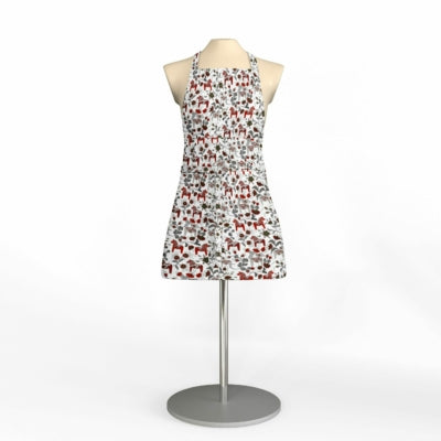 A mannequin displays an apron titled "Leksand Mini Red Dala Horse with Pocket," featuring a white base adorned with a red and gray animal print, made from premium Swedish fabric by Arvidssons Textil, elegantly set against a plain background.