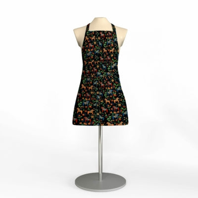 A Leksand Mini Swedish Dala Horse Apron in black with a vibrant animal print, shown on a mannequin torso against a white background; 4 color options available.
