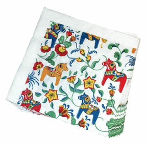 A stack of Leksand Mini Dala Cream napkins featuring vibrant floral patterns and charming Dala horse illustrations from Arvidssons Textil.