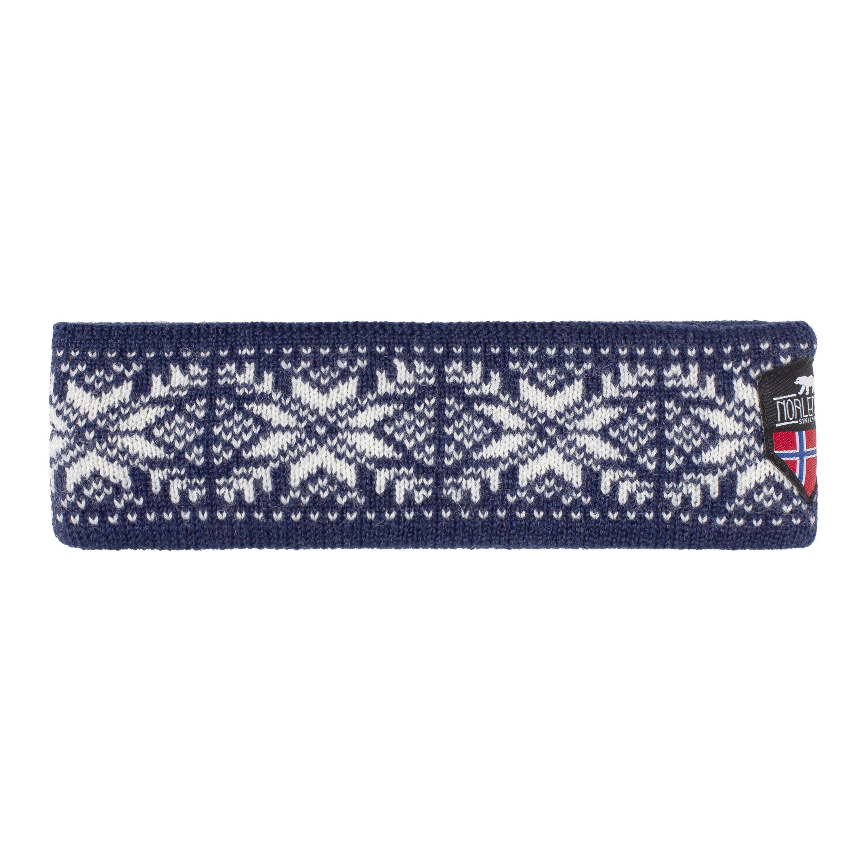 The Snowflake Navy and White Headband from Norway features a navy and white geometric pattern crafted from premium Norwegian wool, with a small patch displaying a red and blue flag that highlights the quality of Norlender Knitwear.