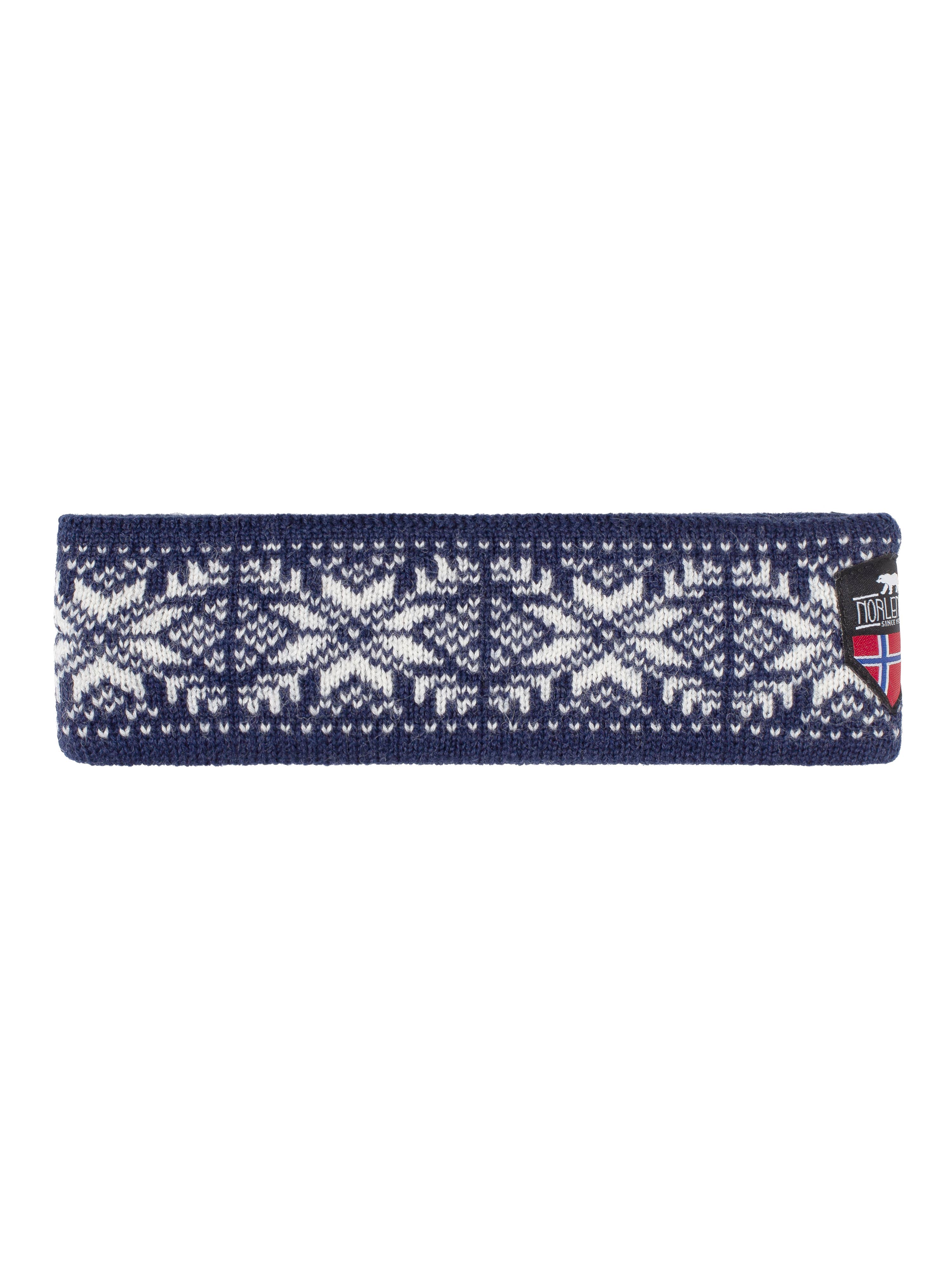 The Navy Snowflake Headband - 402: Navy is a knitted headband made from pure wool, showcasing a delightful white snowflake pattern and adorned with a small flag patch on the side.