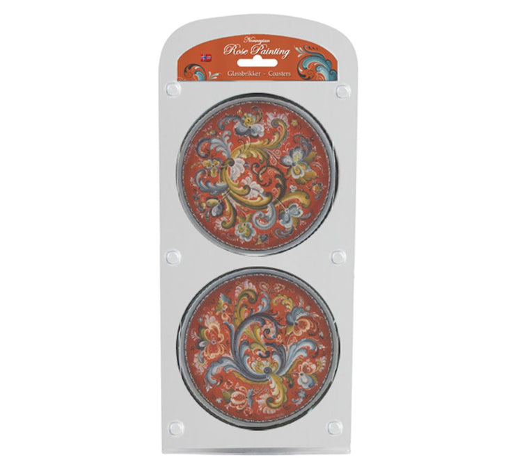 Set of four round coasters with colorful floral designs on a red background, reminiscent of Norwegian Rosemaling, featuring cork backings for stability and elegantly displayed in clear packaging labeled Coaster: Norwegian Rosemaling Coasters 4 pack.