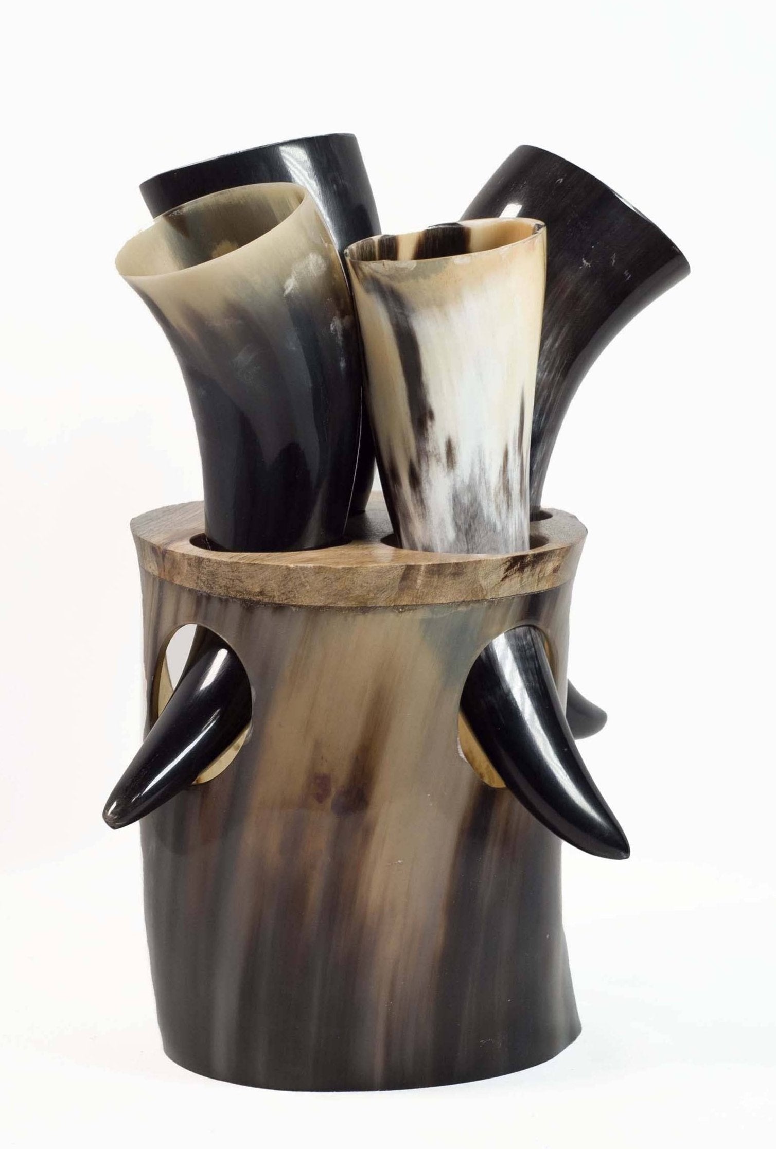 A set of Viking drinking horns, each measuring 6 inches and crafted in genuine ox horn, is held in a cylindrical holder with four protruding decorative tips. The horns feature an authentic design in various shades of black and white.