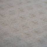 Close-up of a white textured surface with a repeating diamond pattern, similar to the design found on reusable dish towels.