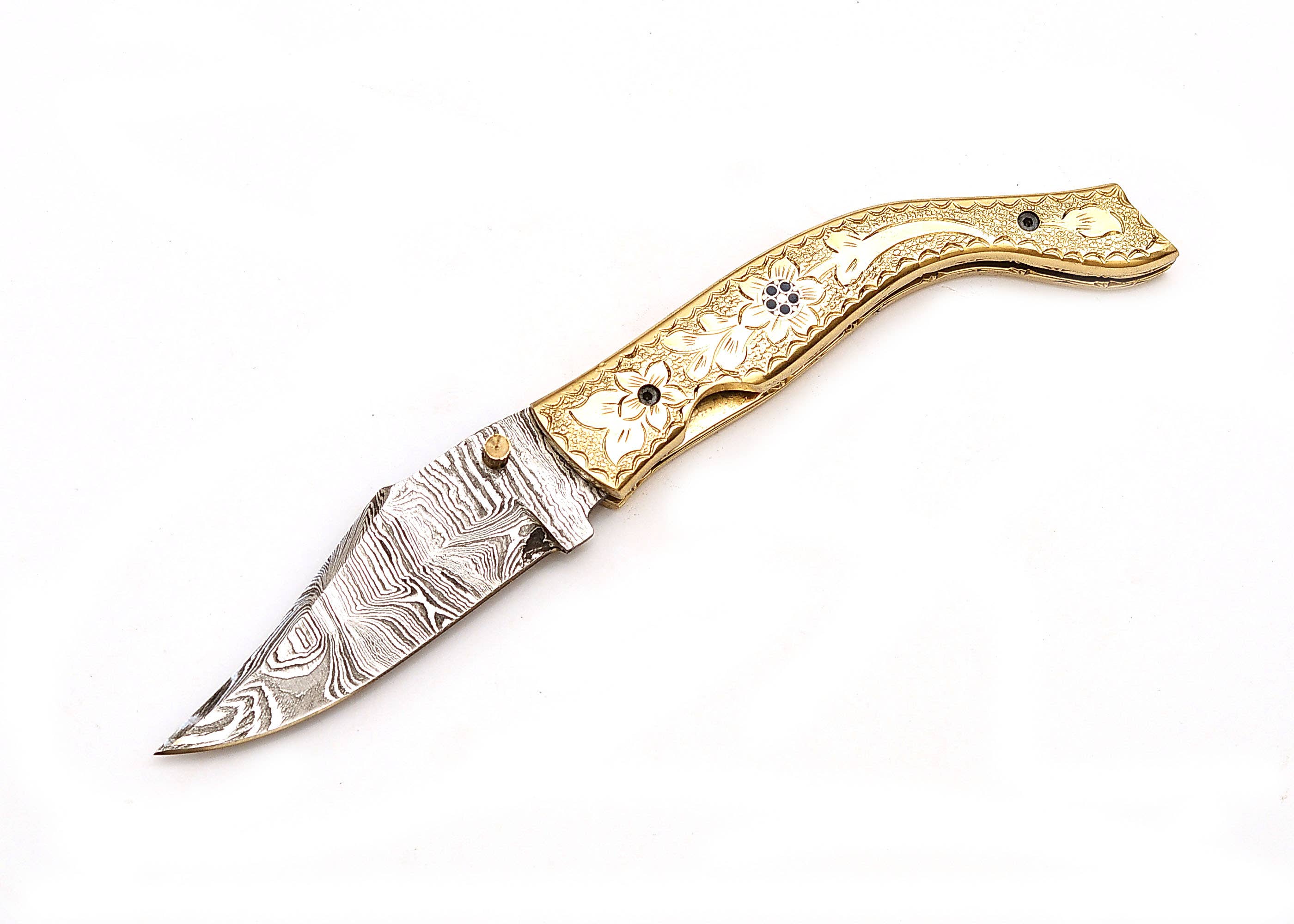 The Exquisite Golden Folding Knife showcases a Damascus steel blade and a brass handle with floral engravings, all set against a white background.