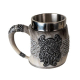 The Coffee Mug: Viking Odin's Horn Drinking Mug features a metal and resin build with Celtic knot designs and a Viking face—an ideal novelty gift for Norse mythology fans.