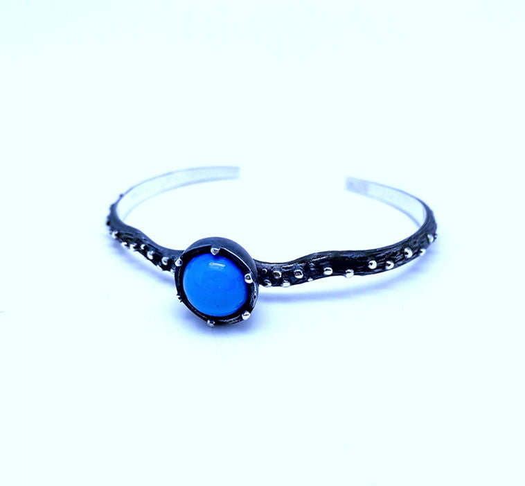 Freja Thin bracelet featuring a textured silver band and a central Swedish Blue ball gemstone, set in an ornate, oxidized silver bezel.