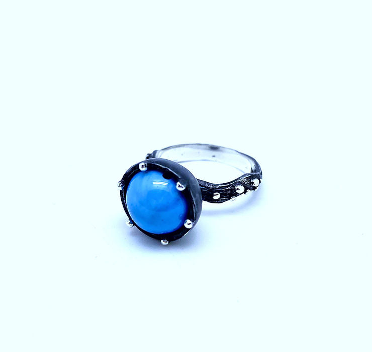 A silver ring called "Freja Thin - Swedish Blue" featuring a prominent Swedish blue ball set in an oxidized silver bezel.