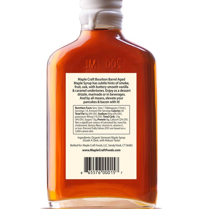 The 6.8 oz bottle of Maple Syrup: Bourbon Barrel - Summer Favorites features a captivating label with rich flavor details and nutritional info. This amber-hued syrup is the perfect dessert drizzle for sweet indulgence.