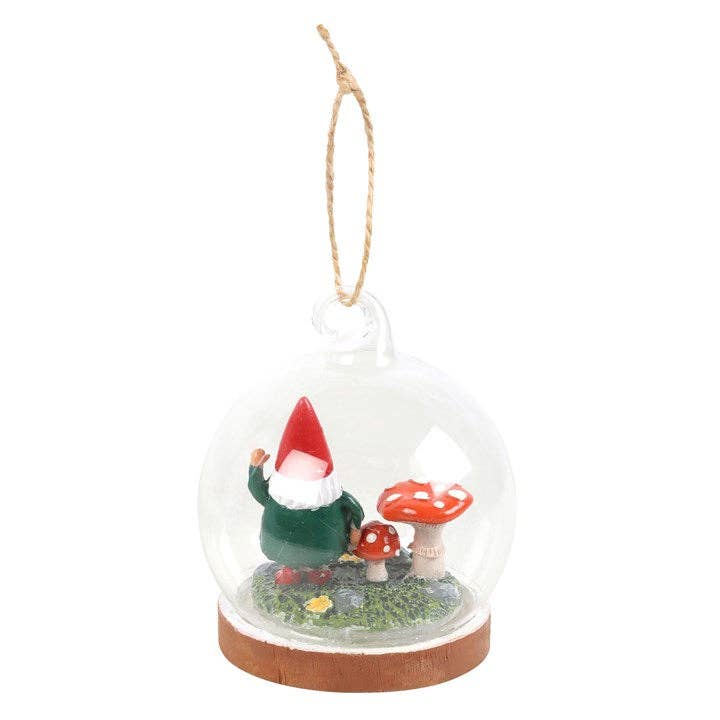 The "Ornament: Gnome Glass Dome" features a delightful gnome wearing a red hat, accompanied by two mushrooms on a grassy base. It creates an enchanting "Gnome Sweet Gnome" scene as it hangs gracefully from a string.