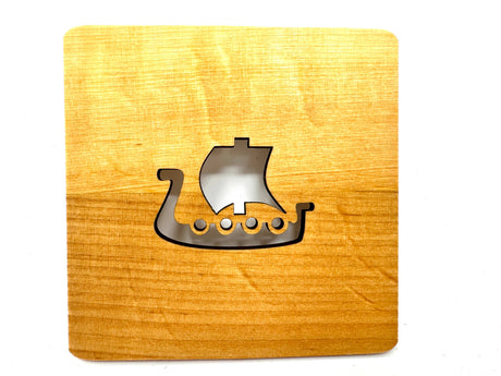 A 4" square alder wood coaster laser cut in the shape of a Viking ship with sail and round shields—perfect for fans of Nordic design.