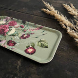 Rectangular Nordic birch veneer tray with a floral pattern on a dark wooden surface next to dried beige grass stems.