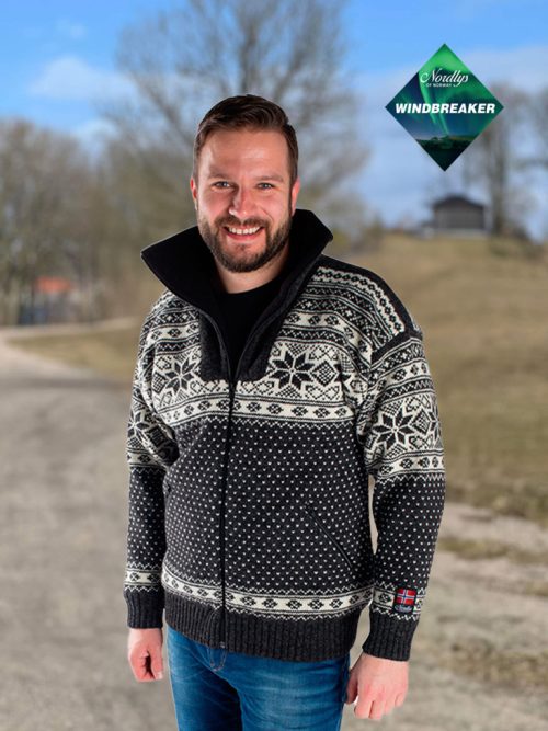 A person wearing a Charcoal Northern Lights Patterned Nordlys of Norway windproof wool jacket for women and men is standing on a path outdoors, with a Windbreaker logo in the top right corner.