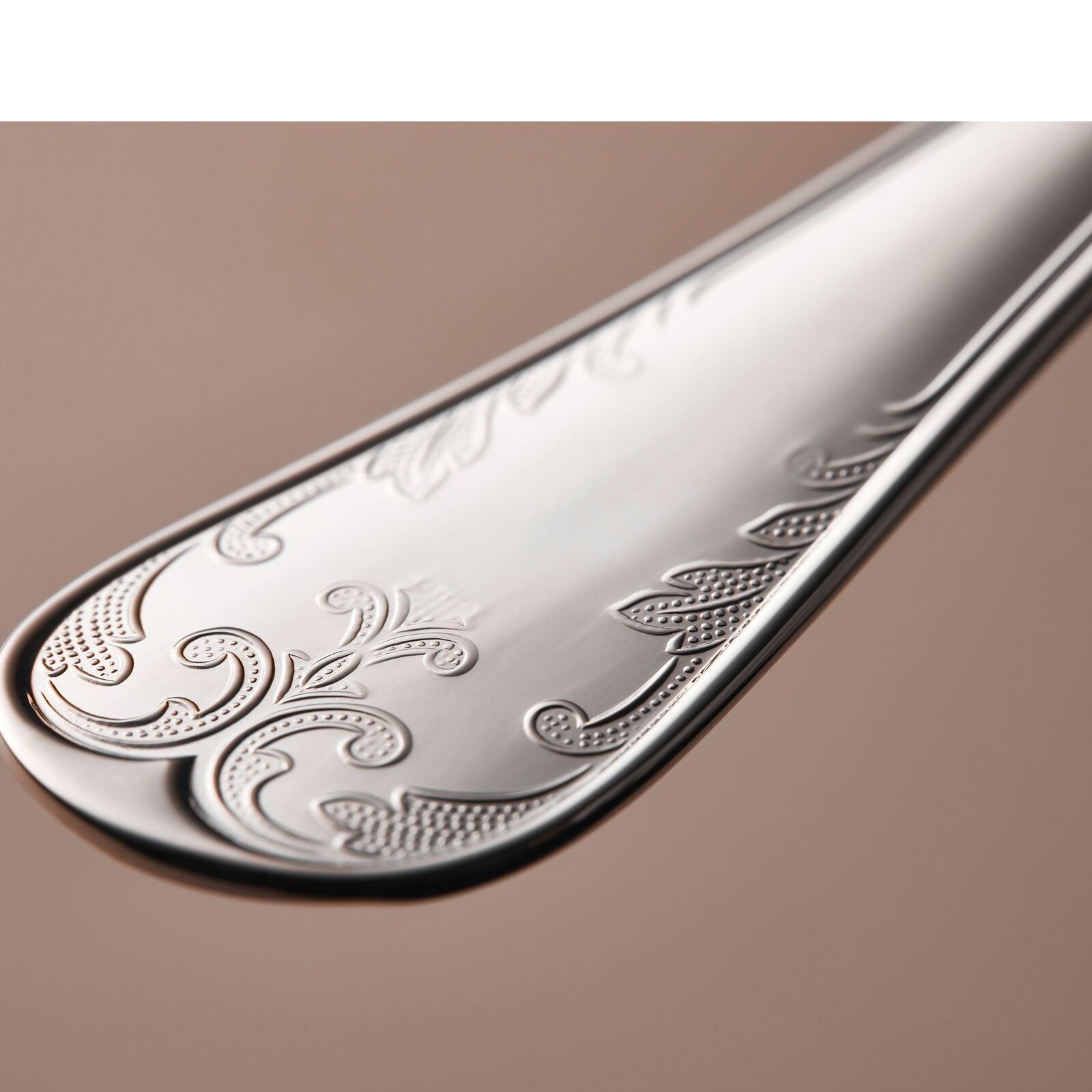 Close-up of an intricately engraved spoon handle from the Gense Silver Dining Set Gammal Fransk 830 collection, showcasing floral and geometric patterns on a neutral background.