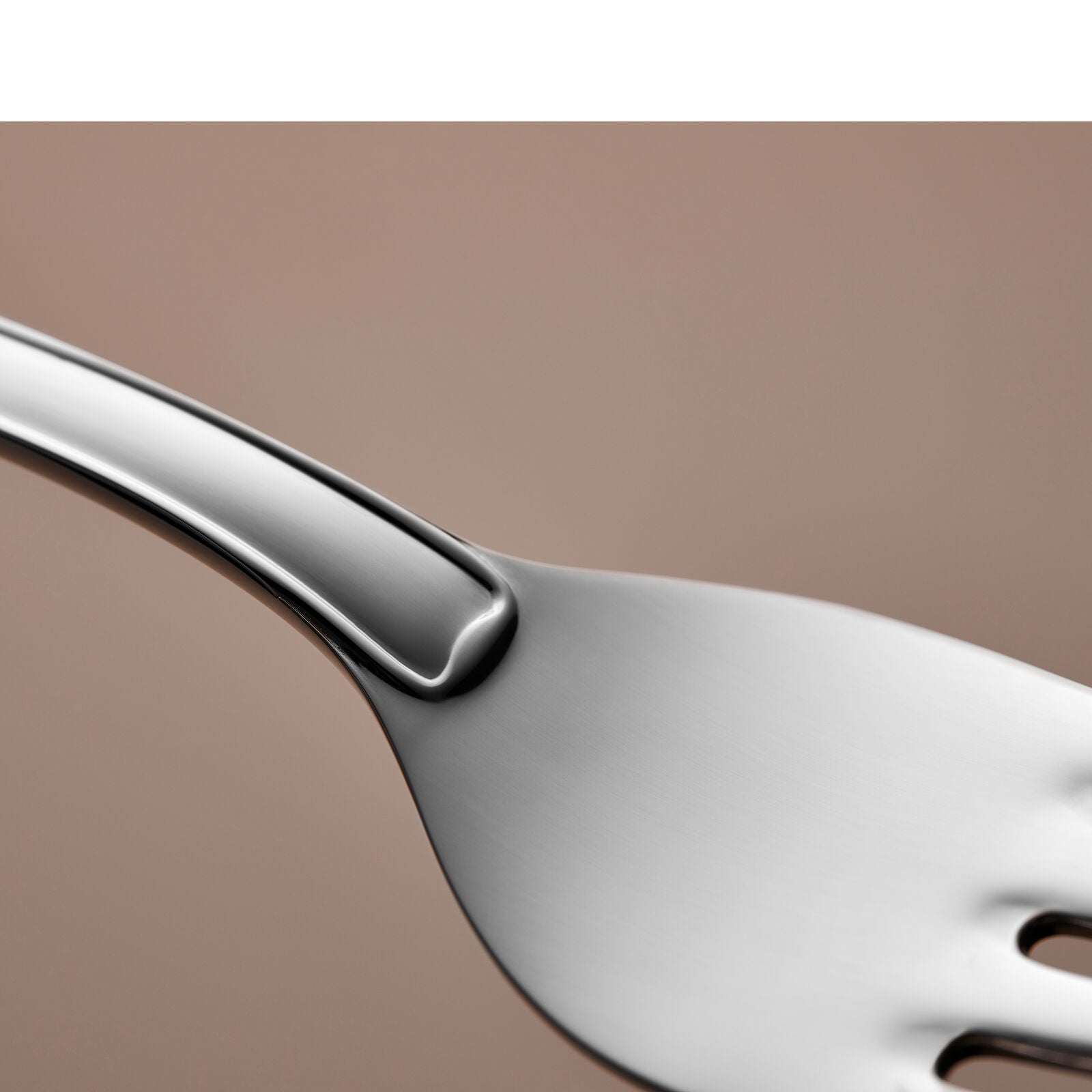 Close-up of a stainless steel fork with a matte finish from the Gense - Silver Dining Set Svensk 830, elegantly crafted against a smooth, light brown background.