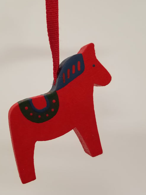 Add festive charm to your décor with the Ornament: Red Wooden Dala Horse Christmas Tree Ornament, 2" tall with painted details and a red string for hanging—a classic Swedish accent against any background.