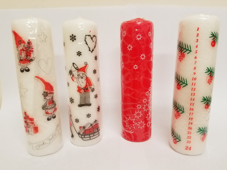 The Candle: 7” Advent Candles set features four decorative candles with holiday-themed designs such as Santa, hearts, stars, and an Advent Calendar countdown.
