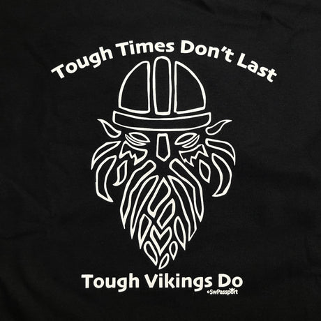 This black T-shirt, named "Tough Times Don't Last, Tough Vikings Do," features a stylized Viking helmet and beard that beautifully captures the Norse spirit with its bold design.