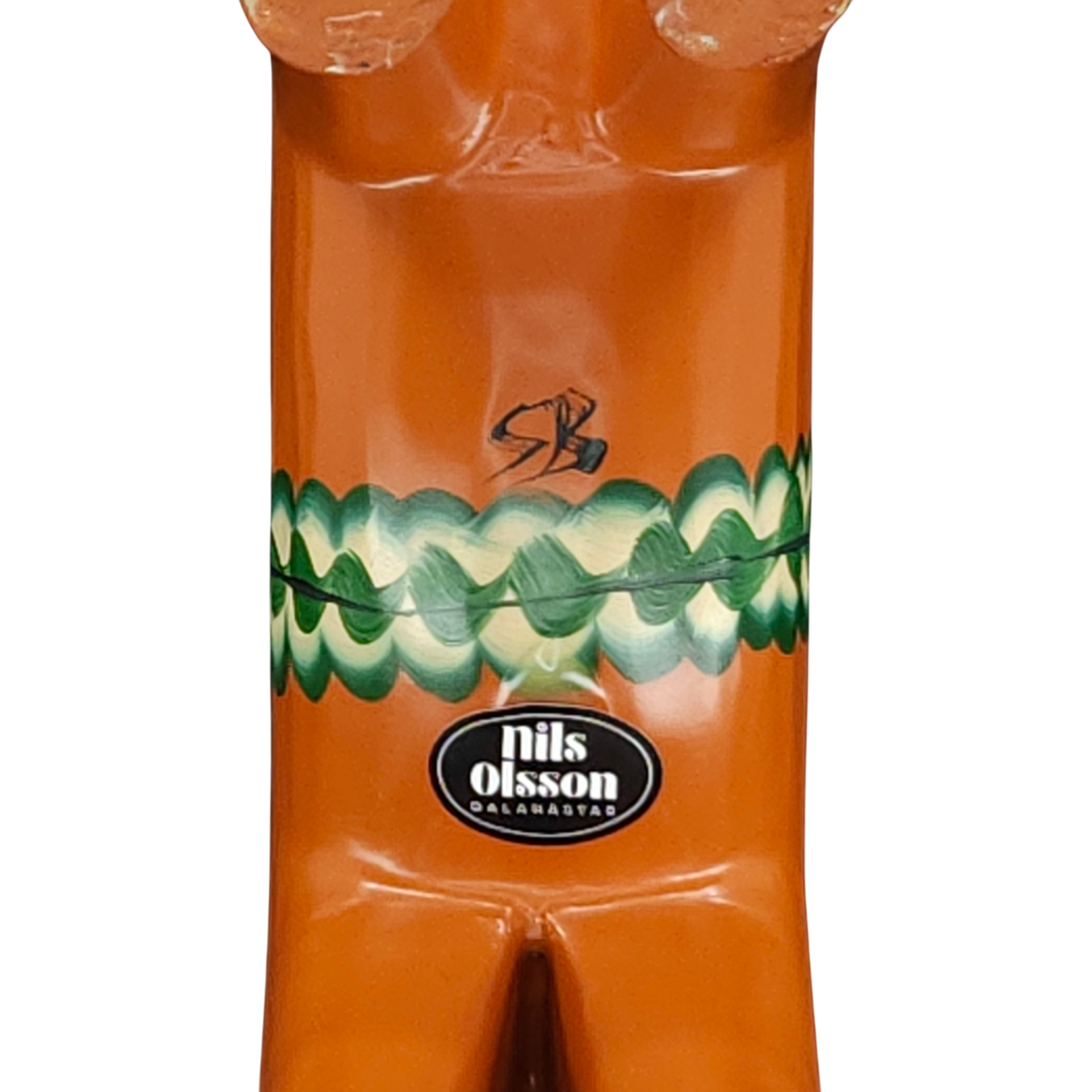 A close-up of the Dala Horse: Antique Inspired Swedish Dala Horse Red-Orange 17cm shows brown ceramic with green wavy patterns, a nils olsson dalahästar sticker, and an inscription above it, evoking classic Swedish design.