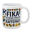 The Mug: Swedish Fika Traditions Wraparound Ceramic Mug (11 oz) by Swedish Gift Store features white ceramic with folk art—flowers, hearts, a blue bird, pastries—and “Fika En Svensk Tradition KaffePaus.” Perfect for Swedish coffee breaks.
