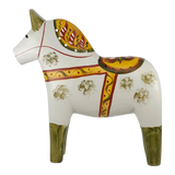 White Swedish Dala horse with green-painted legs and yellow, red, and orange patterns on its body, mane, and saddle.