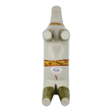 White abstract Dala horse figurine lying on its back, with four visible legs, decorative bands on the body, and a round sticker on the belly.