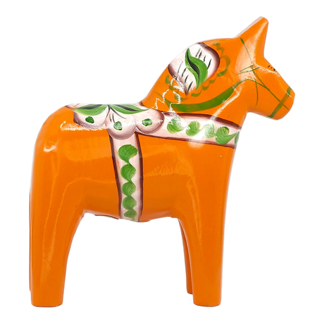 Orange Swedish Dala horse made of wood, decorated with green and white painted patterns, standing upright on a white background.