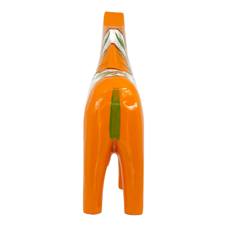 Orange Dala horse figurine shown from behind, featuring a green stripe and painted patterns on its back. Plain white background.