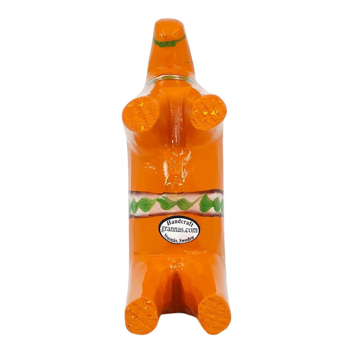 Orange Swedish Dala horse figurine made of pine wood shown on its back, decorated with green and white designs and a visible label on one side.