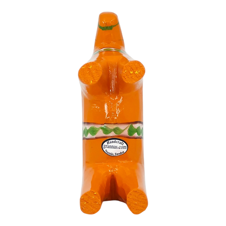 Orange Swedish Dala horse figurine made of pine wood shown on its back, decorated with green and white designs and a visible label on one side.