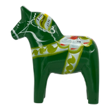 Green Swedish Dala horse made of pine wood, featuring painted white, yellow, and red decorative patterns on its body.