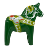 Green Swedish Dala horse carved from wood, featuring yellow, white, and red painted patterns, shown on a white background.