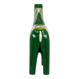 Back view of a green Swedish Dala horse figurine with painted floral patterns, carved from pine wood, set against a plain white background.