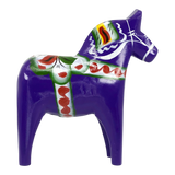 Purple Swedish Dala horse figurine with green, red, and white painted decorations, made of wood, displayed on a white background.