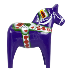 Purple Swedish Dala horse figurine with green, red, and white painted decorations, made of wood, displayed on a white background.