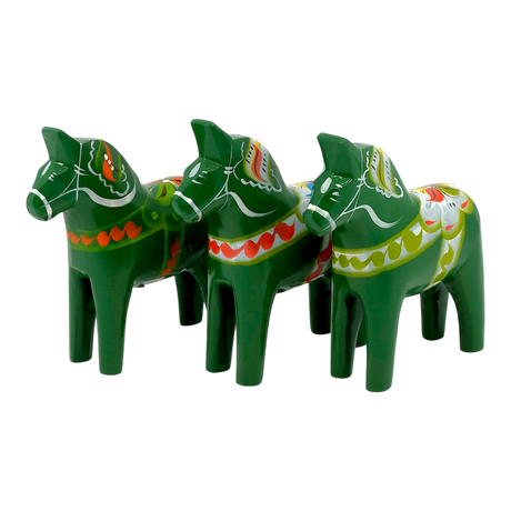 Three green Swedish Dala Horse figurines with colorful painted patterns, standing in a row and facing left on a plain white background.
