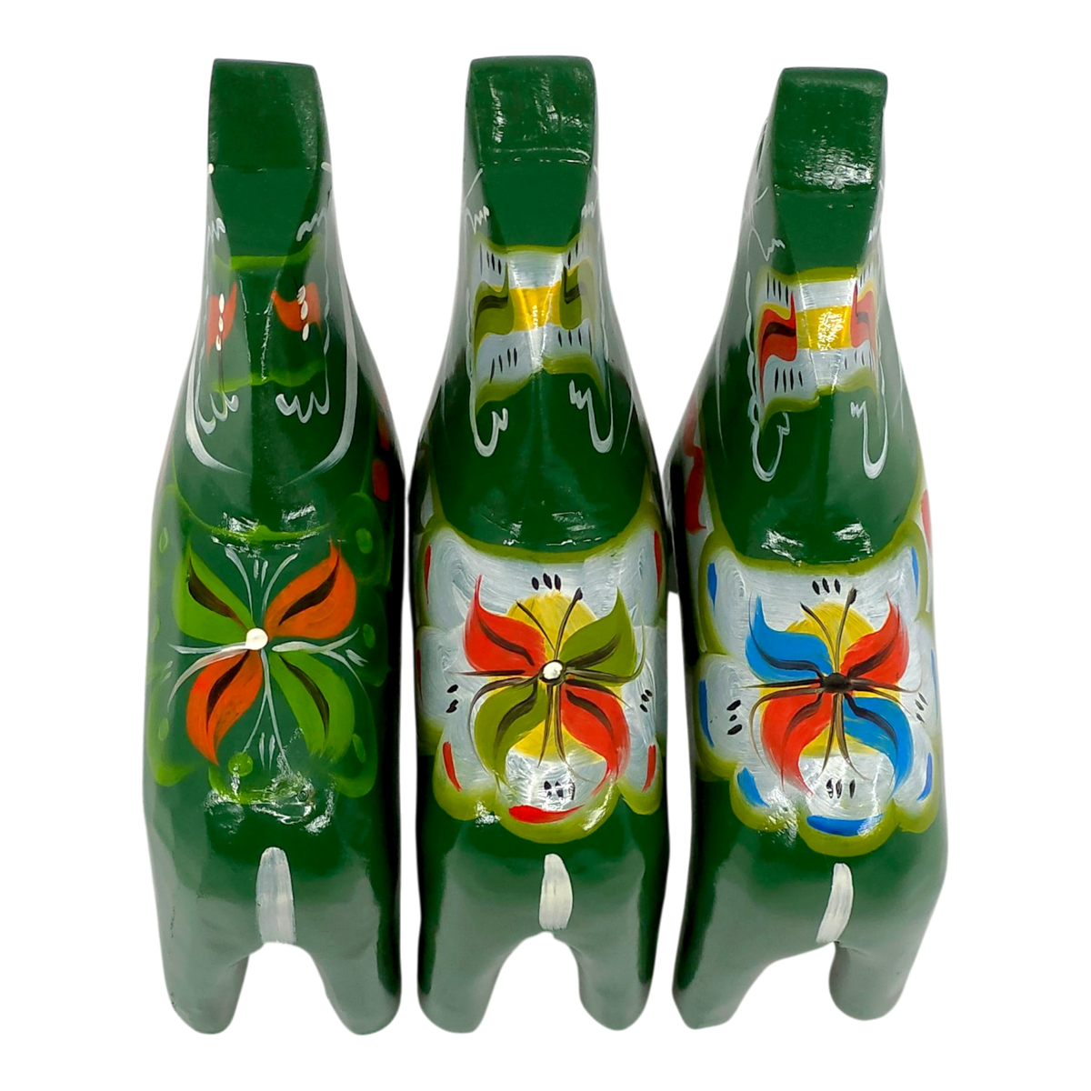 Three green Swedish Dala Horse figurines with colorful floral patterns, viewed from above on a white background.