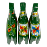 Three green Swedish Dala Horse figurines with colorful floral patterns, viewed from above on a white background.