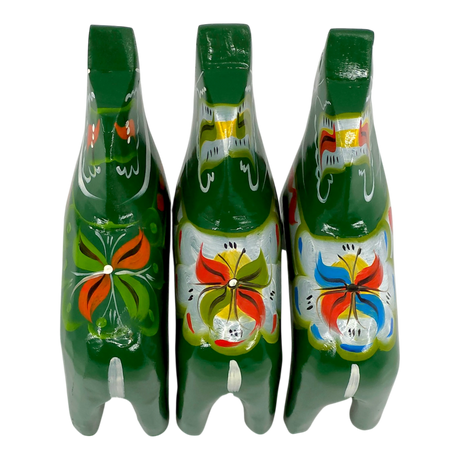 Three green Swedish Dala Horse figurines with colorful floral patterns, viewed from above on a white background.