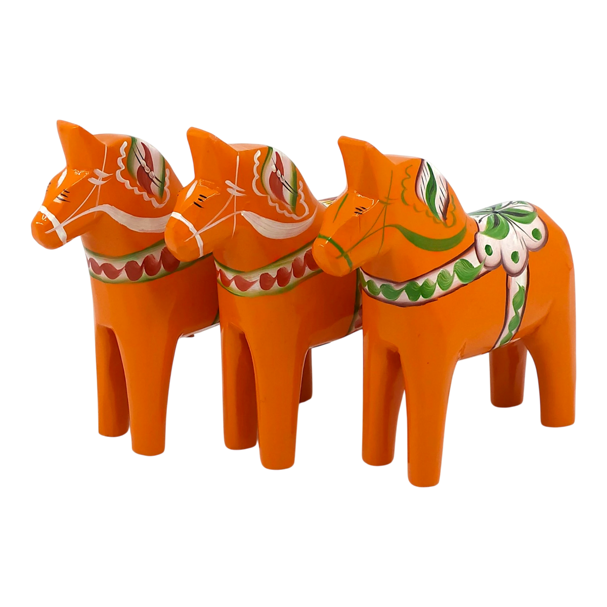 Three orange Swedish Dala horses with traditional painted patterns, arranged in a row on a white background.