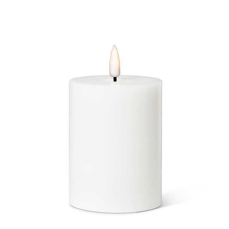 The 4" LED Pillar Candle in white features a cylindrical shape with a realistic LED flame that flickers gently at the top, providing a soothing glow for up to 150 hours.