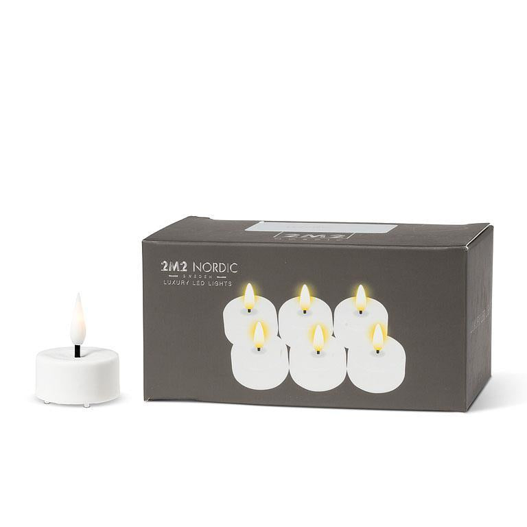 Box of Candle: 1.5" LED Tealight, White (6-Pack) with one candle displayed outside the box. The package boasts six LED candles with a realistic 3D flame effect, each powered by a CR2032 battery to offer lasting elegance and ambiance.