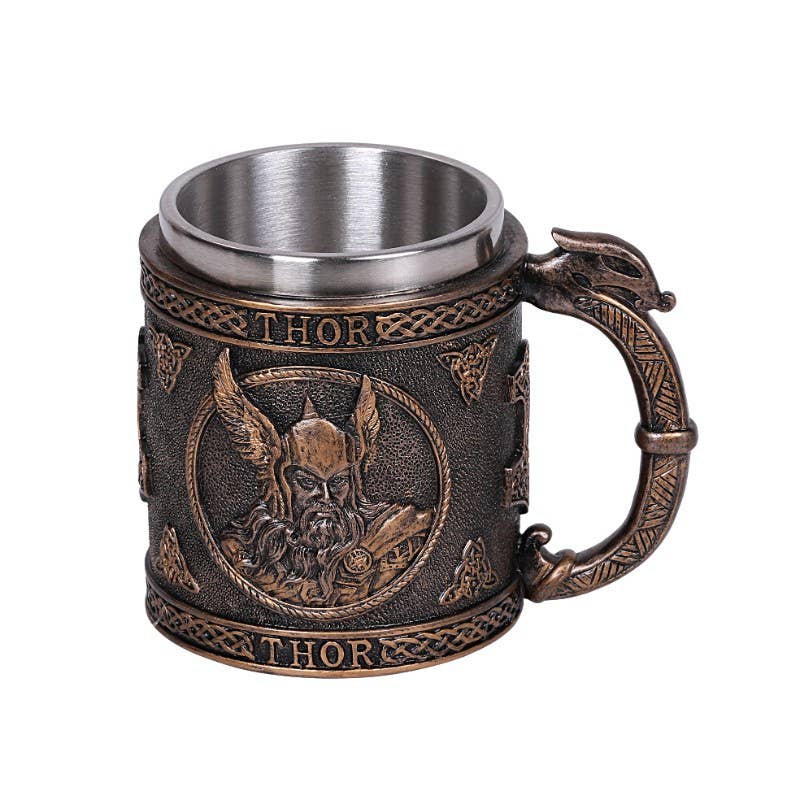 The Mug: Norse God Thor Viking Mug is crafted from metal and resin, featuring embossed Norse designs, an image of Thor with his name engraved above and below, and a durable stainless steel interior for lasting use.