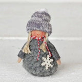 Gnome ornament wearing a grey knit sweater and matching beanie with a white wooden snowflake.