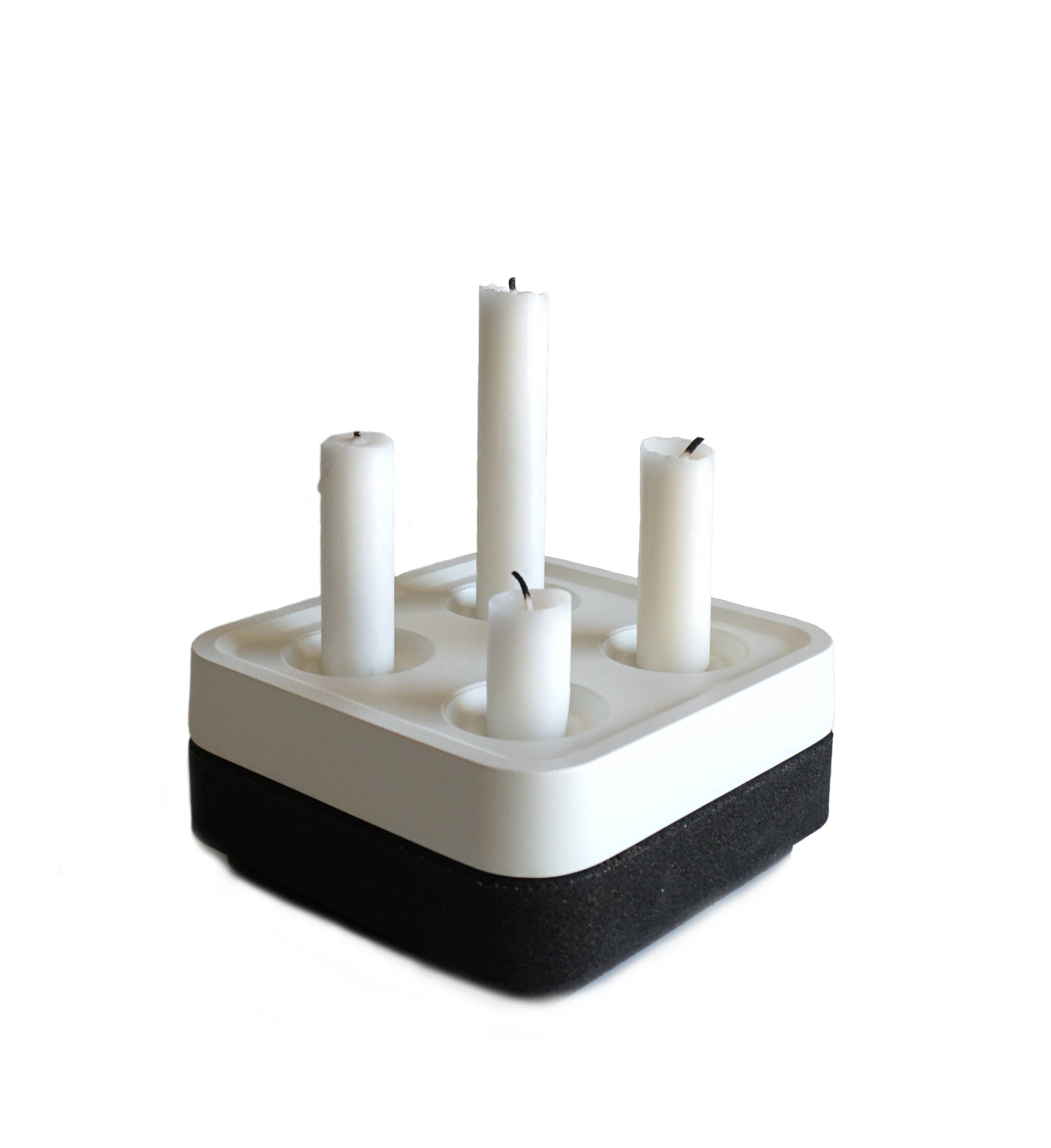 The Stumpastaken Fyran Four Candle Holder is a square, white powder-coated holder crafted from 100% recycled material—an elegant embodiment of sustainable interior decor and timeless Swedish design.