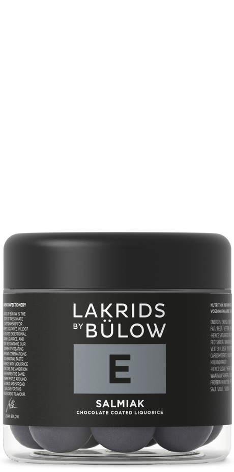A jar with a black lid and black label displaying “Lakrids by Bülow E Salmiak,” containing round Nordic candy pieces.