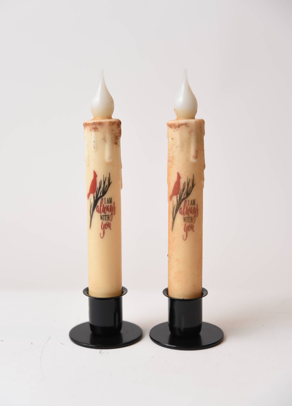 The "I am Always with You Cardinal" LED Timer Taper Candles feature faux wax drips, black bases, cinnamon dusting, a red cardinal design, and heartfelt text—perfect battery-operated accents for farmhouse décor.