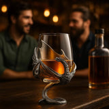 A Wine Glass: Medieval Dragon Viking Goblet Mug – Fantasy-Inspired Drinkware (9oz) sits on a bar counter, held in a metal dragon-themed holder, while two men converse in the blurred background.