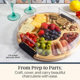 Bamboo charcuterie board with sections filled with cheese, fruit, nuts, and meats, featuring a clear plastic lid with a black locking handle.