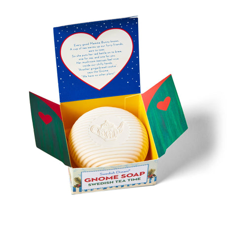 A round white Gnome Soap Swedish Tea Swedish Dream Bar rests in an open, festive gift box, featuring a teapot design and a short poem on the lid.